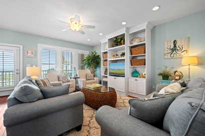 Unwind in your calming coastal-themed living space with plush seating, ocean-inspired decor, and entertainment center—perfect for cozy evenings after beach adventures.
