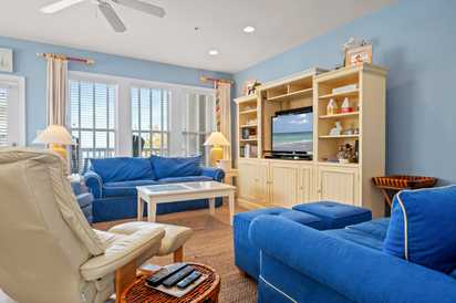 Unwind in your coastal-inspired living room with comfortable blue seating, built-in entertainment center, and soothing ocean views from your window.