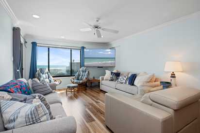 Unwind in your bright living room with stunning ocean views and cozy seating for your perfect beach getaway.