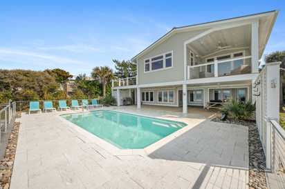 Modern coastal home with private swimming pool surrounded by tropical landscaping and spacious outdoor entertaining areas.